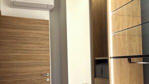 Una habitación moderna con un armario de madera, estante empotrado y aire acondicionado instalado en el techo.