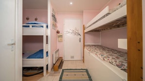 A small, narrow room with bunk beds, a door, and a radiator. - Studio in France with Mountain Views (Allos)