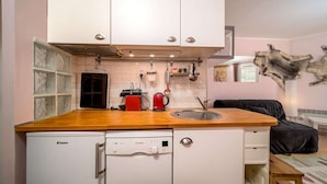 A compact kitchen with white cabinets, a Bosch dishwasher, a Canon refrigerator, and a red coffee maker. - Studio in France with Mountain Views (Allos)