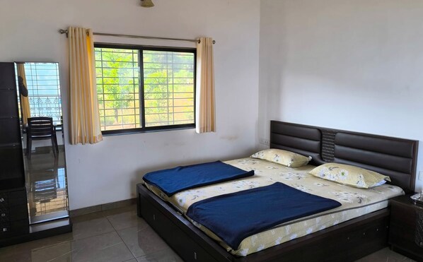 Un dormitorio con cama, cortinas, una ventana y un escritorio.