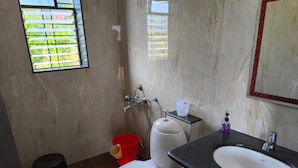 A bathroom with a toilet, bidet, sink, and a window with blinds. - Eagle Eye Resort (Mahabaleshwar)