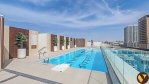 A rooftop swimming pool with a clear blue sky in the background. - Vogue | Binghatti Galaxy JVC near Circle Mall (Dubai)