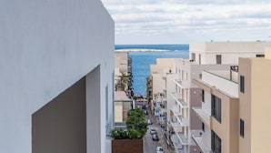 A residential building with a narrow street, balconies, and a view of the sea. - Seashells Apartment with Sea View Terrace (Bugibba,)