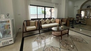 Un espacio moderno para relajarse, con un conjunto de sofás, una mesa de centro de vidrio y un tapete decorativo.