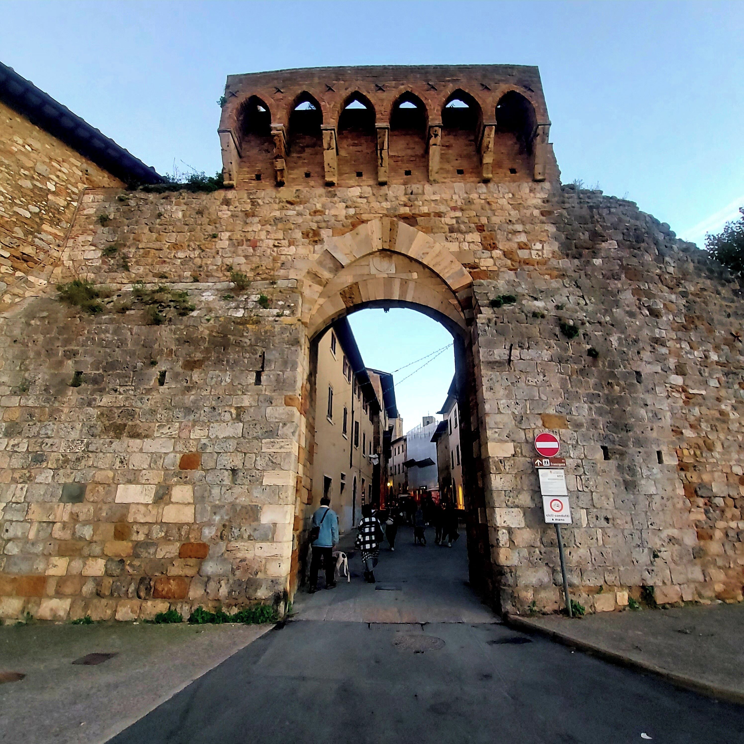 Un arco de piedra con un letrero que indica prohibido el acceso.
