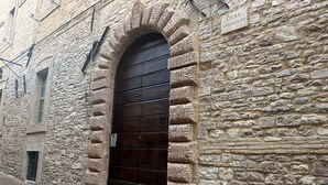 A stone building with a large arched entrance and a sign reading "CASA SBARAGLINI". - Palazzo Sbaraglini (Assisi)
