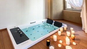 A spa room with a large bathtub, candles, and a decorative ceiling. - Palazzo Sbaraglini (Assisi)