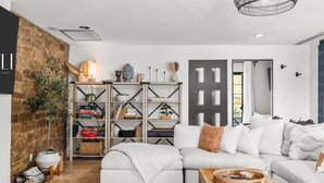 A modern living room with a white sofa, a wooden coffee table, and a bookshelf. - Palo Verde Experience|Zen-Inspired Resort Oasis (Phoenix)