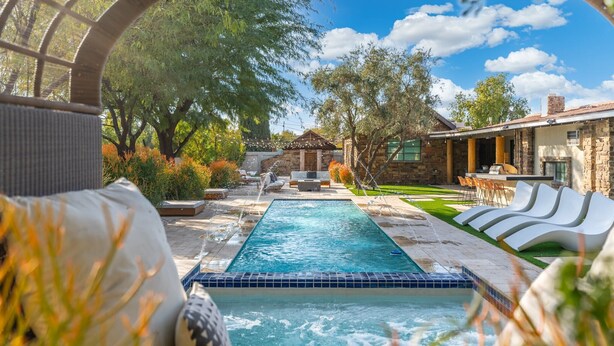A pool area with a hot tub, lounge chairs, and a stone building in the background. - Palo Verde Experience|Zen-Inspired Resort Oasis (Phoenix)