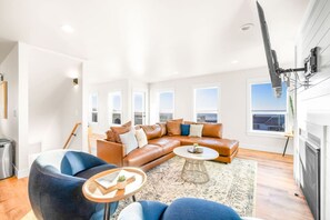 Een moderne woonkamer met een leren bank, een salontafel en uitzicht op de stad.