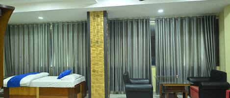 Una habitación de hotel moderna con una cama, un escritorio y dos sillas.