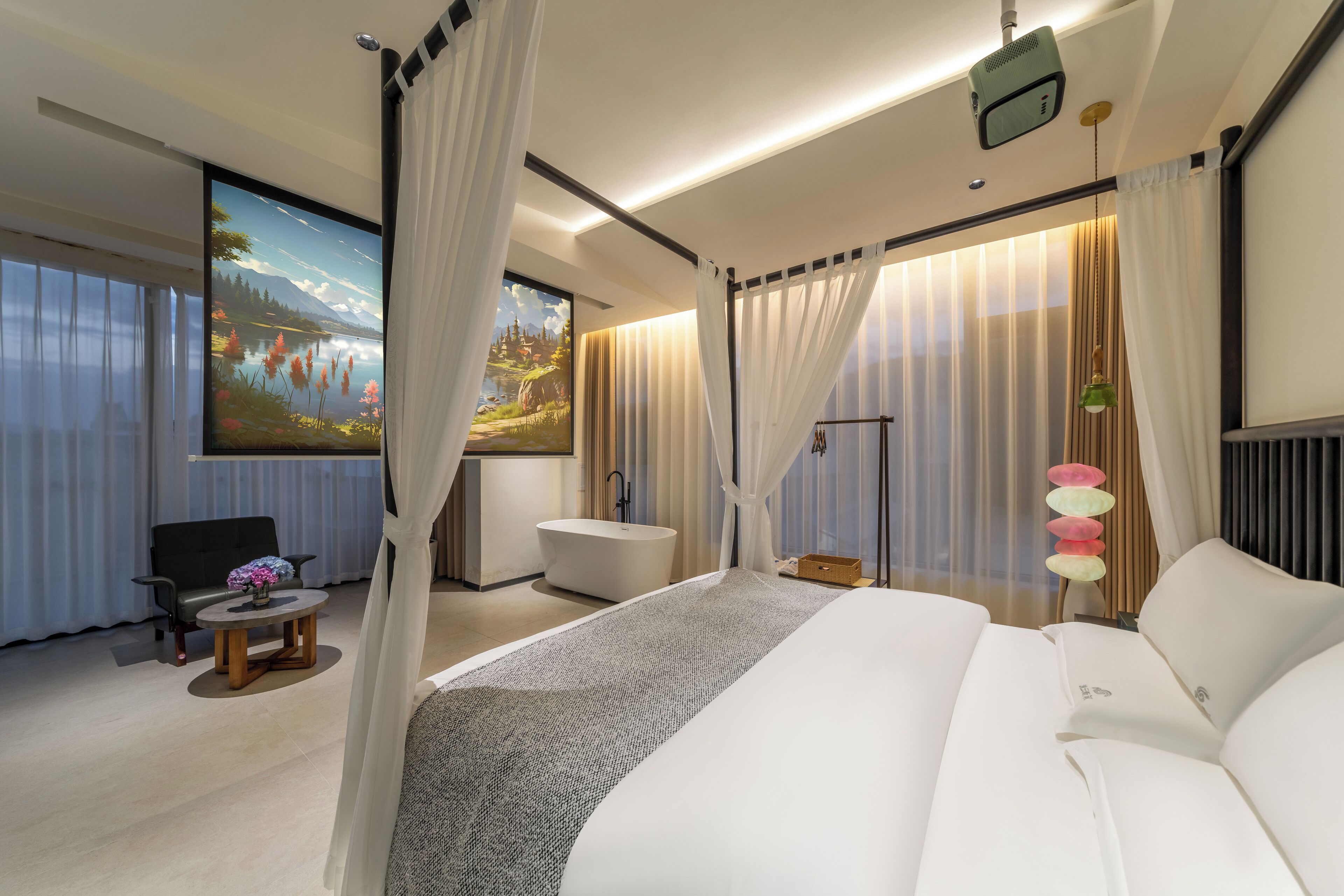 Une chambre d’hôtel moderne dotée d’un grand lit, d’un coin salon avec un fauteuil et une table, d’une baignoire et d’une grande fenêtre avec des rideaux.