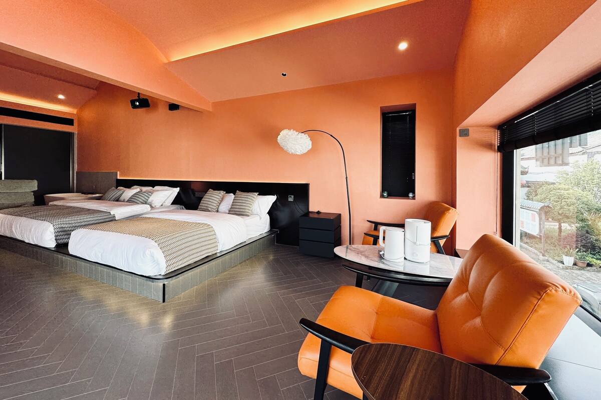 A modern hotel room with a large bed, a desk, and a view of the outside.
