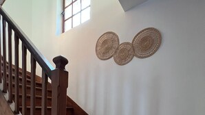A wooden staircase with a handrail, leading to a landing with a small window and decorative wall art. - Appartement à Sevran (Sevran)