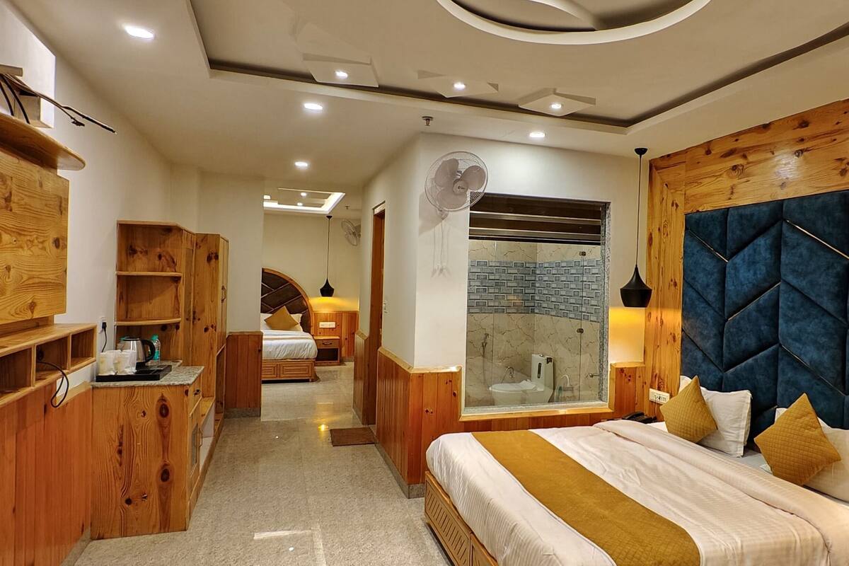 Une chambre à coucher moderne avec une tête de lit en bois, un grand lit, une table de chevet et une armoire intégrée.