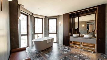 A modern bathroom with a freestanding bathtub, a vanity with a sink, and a large mirror.