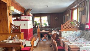A traditional dining area with wooden furniture and red cushions, featuring a vintage red and white refrigerator and a wooden headboard with a heart-shaped cutout. - Dream hotel  (Staffa)