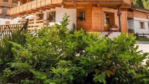 A multi-story wooden building with balconies, labeled "Dream Hotel," surrounded by lush greenery and mountains. - Dream hotel  (Staffa)