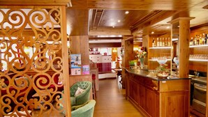 A wooden interior with a bar area, kitchen in the background, and a decorative partition. - Dream hotel  (Staffa)