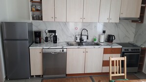 A compact kitchen with a dishwasher, stove, and coffee maker.