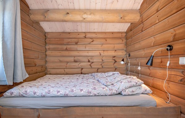 A wooden cabin room with a bed, two wall-mounted lamps, and a power outlet. - Amazing home in Lesjaskog with WiFi (Lesjaskog)