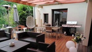 An outdoor patio with wicker furniture, a grill, and a dining area. - Room at Sylvie's, breakfast included (Val-d'Izé)