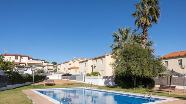 A residential area with a swimming pool, palm trees, and apartment buildings. - Golden Coast Retreat by Fidalsa (Creixell)