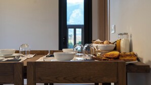 A dining table set with bowls, plates, glasses, and breakfast items like toast and eggs. - Atman Eco Lodge (Souli)