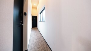 A hallway with a door labeled '101', a window, and a textured carpet. - Apartment Sanjo (Nara)