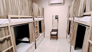 A room with bunk beds, a chair, and a small mirror on the wall. - Marol nandham dormitory  (Mumbai)