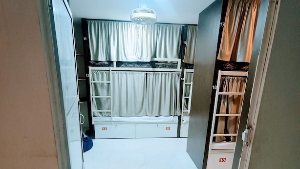 A dormitory room with bunk beds, a ceiling fan, and a wardrobe. - Marol nandham dormitory  (Mumbai)