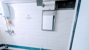 A bathroom with a toilet, a sink, a shower, and a hand dryer. - Marol nandham dormitory  (Mumbai)