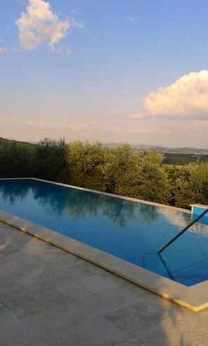 A swimming pool with a clear view of the surrounding landscape and distant hills.