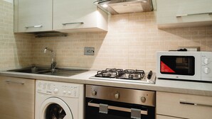 A modern kitchen with a stainless steel gas stove, a built-in microwave, a washing machine, and a dishwasher. - Casa di Ziva in Rome (Rome)