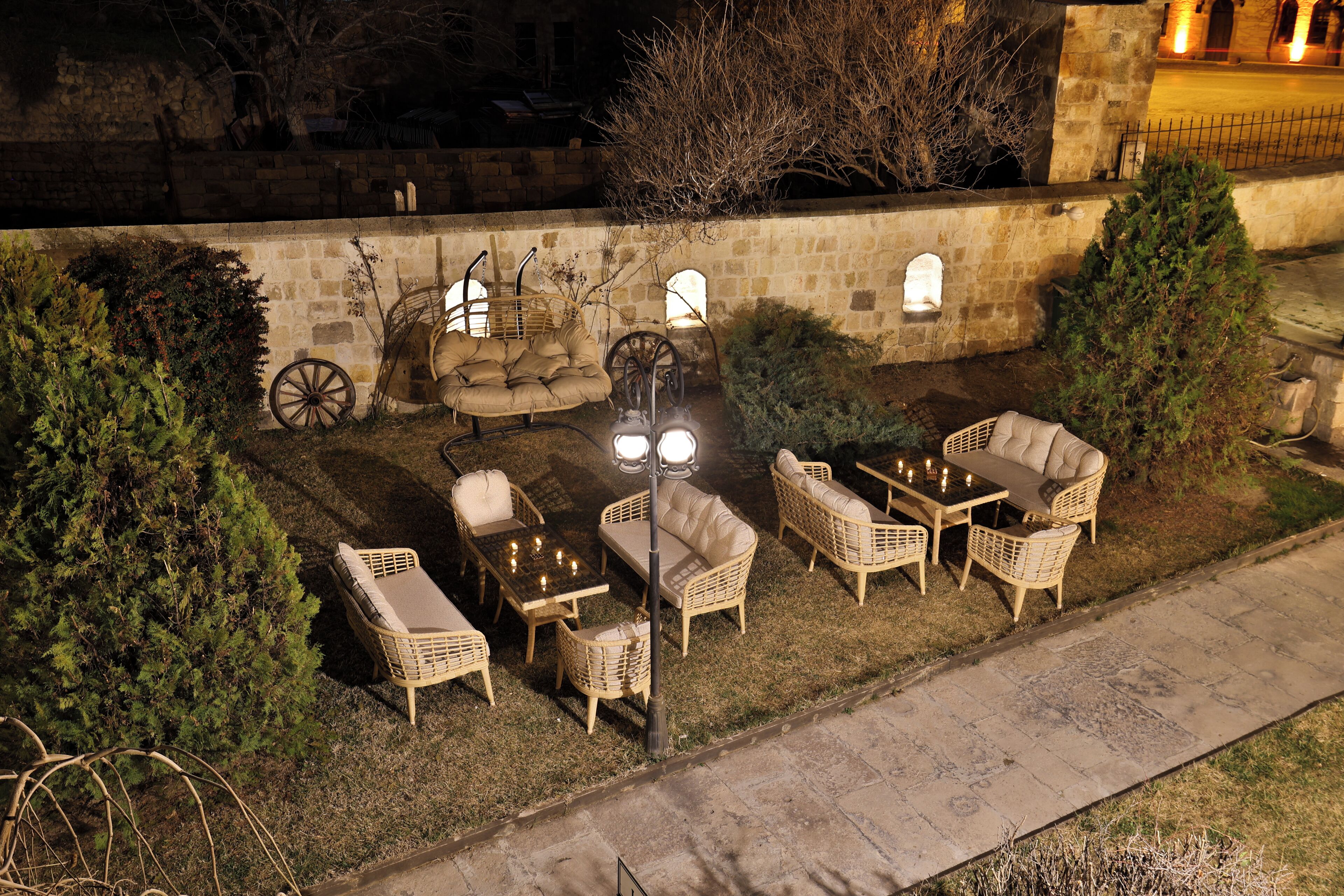 An outdoor patio with wicker furniture, a table, and a lamp post.