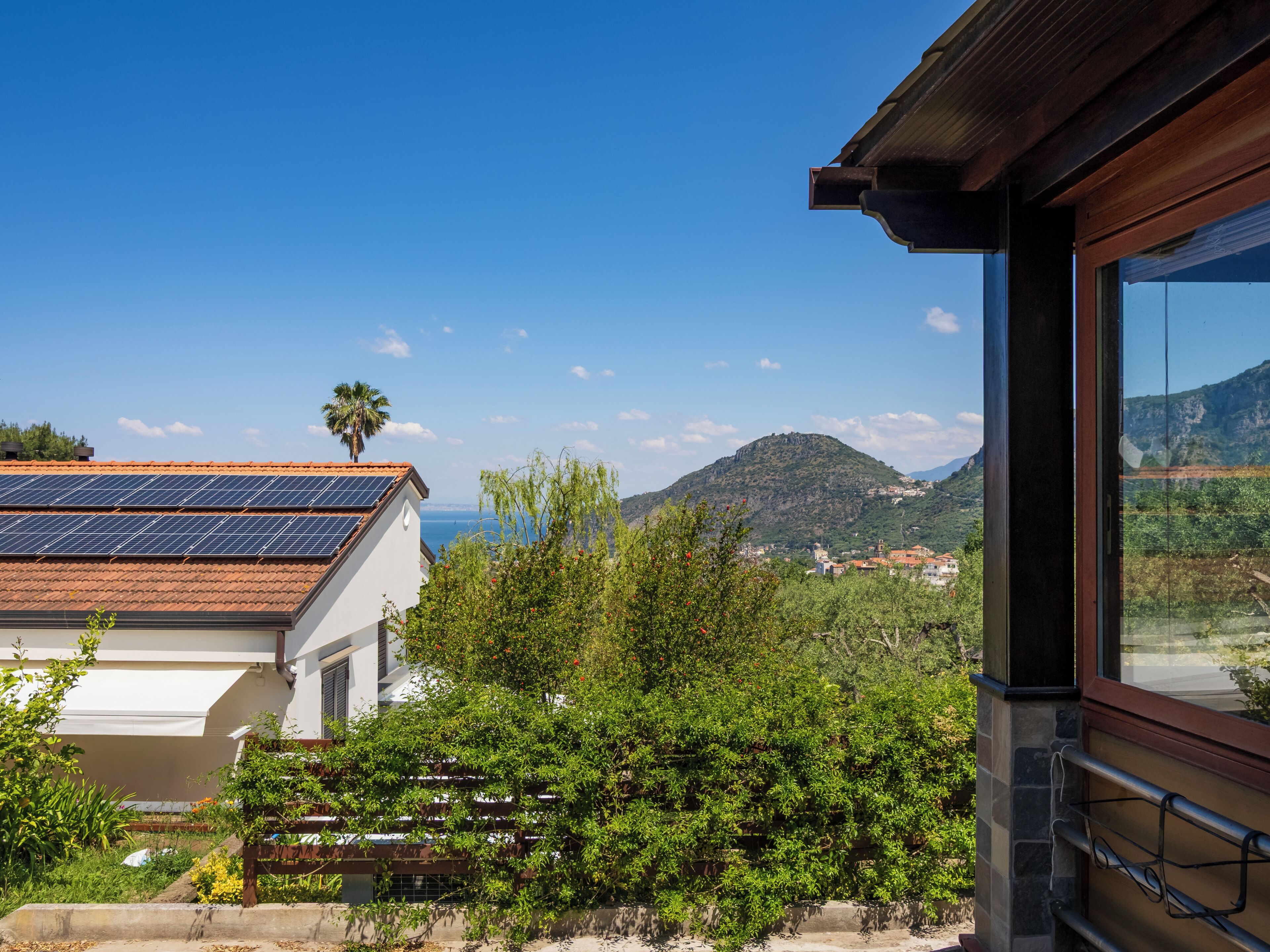 Un edificio con un tetto solare, vista su una montagna e cielo sereno.