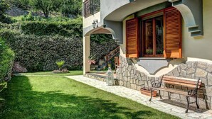 A two-story building with a stone facade, wooden shutters, and a stone bench. - 🌺Villa dei Fiori – Elegance, Nature & Serenity on the Sorrento Coast (Vico Equense)