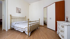 Un dormitorio con cama, cómoda, armario y espejo.