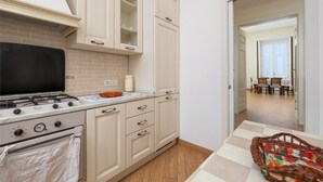 Una cocina con estufa a gas, armarios y comedor con mesa y sillas.