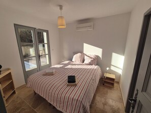 A bedroom with a bed, a window, a door, and a ceiling light. - Spacious 4 bedroom mas with AC, WiFi, wonderful view in a nice and quite place (Lioux)