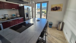 A modern kitchen with a large island, stainless steel appliances, and a view to the outside. - Spacious 4 bedroom mas with AC, WiFi, wonderful view in a nice and quite place (Lioux)