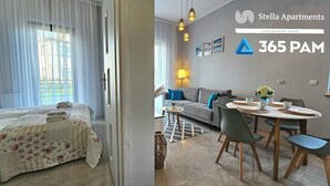 A modern apartment with a bed, sofa, dining table, and chairs. There are curtains, a lamp, and a small plant. - Apartament Loft 9 - 365PAM (Ustronie Morskie)