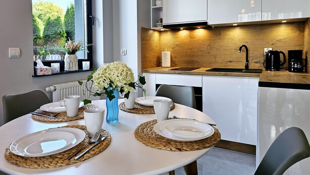 A modern kitchen with white cabinets, a wooden countertop, and a sink. - Apartament Loft 9 - 365PAM (Ustronie Morskie)