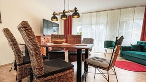En matplats med flätade stolar, ett träbord och en modern hänglampa.