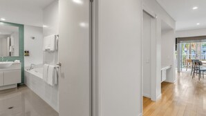 A modern bathroom with a large mirror, white sink, and bathtub. - The Sand Resort Kingscliff - Dual Key Pool View (3208/09) (Tweed)