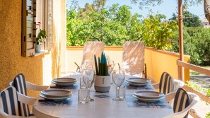 A round table set for dining with plates, glasses, and a centerpiece.