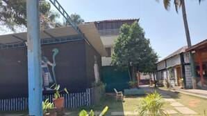 A courtyard with a mural, potted plants, and a small seating area. - Yogi Golden Resort (Mysore)