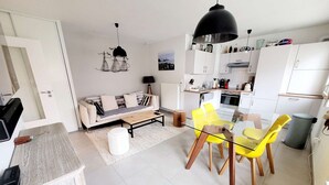 Een modern appartement met een woonekamer, eethoek en keuken.