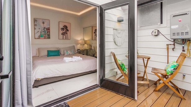Une chambre à coucher avec un lit, des tables de chevet et des œuvres d’art accrochées au mur.