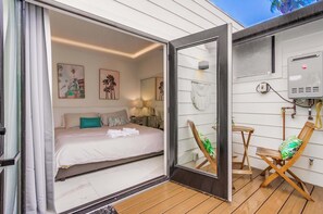 A bedroom with a bed, bedside tables, and artwork on the wall. - Ocean Beach Luxury | A/C, Cal King & Soaking Tub (San Diego)